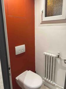 a bathroom with a toilet and a window and a radiator at Appartement au cœur des alpes in Albertville