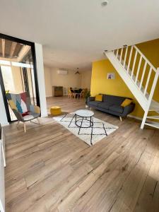 salon z kanapą i schodami w obiekcie La Sardinette w mieście Pessac