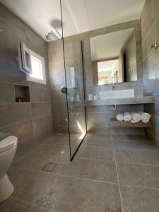 a bathroom with a shower and a toilet and a sink at XALAKAS SUMMER HOUSE in Empourios