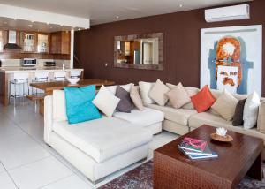 a living room with a white couch with colorful pillows at Marine Square Luxury Suites in Hermanus