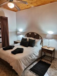 Un dormitorio con una gran cama blanca con almohadas. en Lake St Lucia Villas, en St Lucia