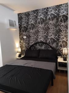 ein Schlafzimmer mit einem schwarzen Bett und einer schwarz-weißen Wand in der Unterkunft Nice 1BR Condo Unit by Lee Portum in Marilao