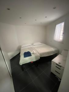 een kleine witte kamer met een bed en een bureau bij Napoli centro casa con due camere e cucina in Napels