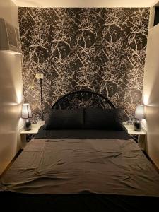 Schlafzimmer mit einem Bett mit einer schwarz-weißen Tapete in der Unterkunft Nice 1BR Condo Unit by Lee Portum in Marilao