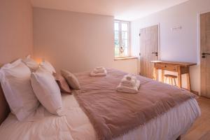 a bedroom with a large bed with towels on it at Garenne in Livron-sur-Drôme