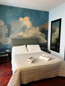 a bedroom with a large bed with two towels on it at Dolce Vita Guest House in Rome