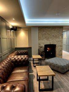a living room with leather furniture and a fireplace at The Three Pickerels in Mepal