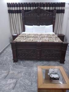 a bedroom with a large bed with a wooden frame at Defence Guest House in Karachi