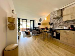 cocina y sala de estar con mesa y sillas en Stunning lovely flat with Pool and strong Wi-Fi, en Arona
