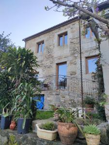 Casa de Chica Ecoturismo في Lousame: بيت حجري أمامه نباتات