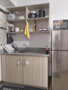 eine Küche mit einer Spüle und einem Kühlschrank in der Unterkunft Nice 1BR Condo Unit by Lee Portum in Marilao