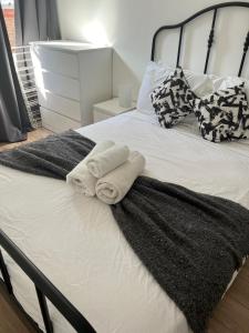 a bed with two towels and pillows on it at Fully equipped 2 bed flat on Old Compton St! in London
