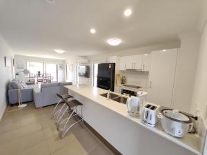 cocina y sala de estar con armarios blancos y encimera en Spacious private en-suite with air-con en Kallangur