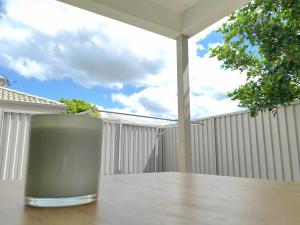 uma chávena em cima de uma mesa de madeira em Spacious private en-suite with air-con em Kallangur