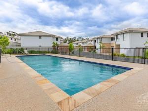 una piscina en un patio con casas en Spacious private en-suite with air-con, en Kallangur