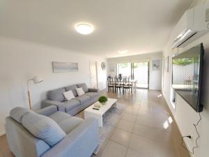 sala de estar con sofá y mesa en Spacious private en-suite with air-con en Kallangur