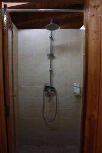 a shower with a shower head in a bathroom at Albergue La Casa del Camino in Valverde de la Virgen