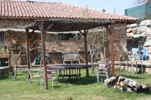 um gazebo com uma mesa e cadeiras num quintal em Albergue La Casa del Camino em Valverde de la Virgen