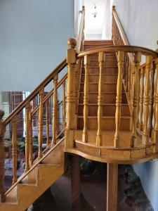 a wooden spiral staircase with wooden treads at Heroes Garden Lodge in Pietermaritzburg