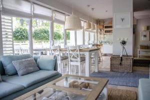 a living room with a blue couch and a table at Playa Baltis Apartamenty Club di Mare in Międzyzdroje