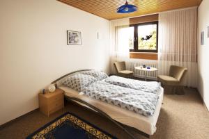 een slaapkamer met een bed, een tafel en een raam bij Ferienwohnungen Casa Ri(e)sig in Leiwen