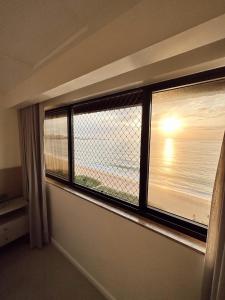 a room with a window with a view of the ocean at Praia da Costa, SUNRISE STAY in Vila Velha