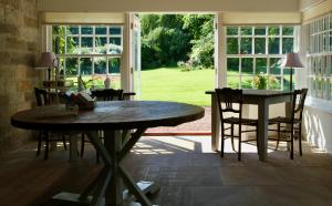 een eetkamer met een tafel en stoelen en een raam bij Thistleyhaugh farmhouse in Longhorsley