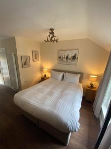 a bedroom with a large white bed with two lamps at The New Forest Inn in Lyndhurst