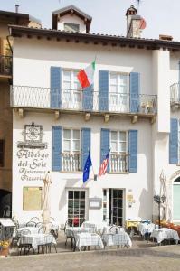 un bâtiment avec des tables et des chaises devant lui dans l'établissement Albergo Del Sole, à Varenna