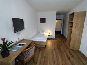 a small room with a desk and a table with a computer at Hotel Sonnenkeller in Neu-Ulm