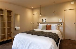 1 dormitorio con 1 cama grande con sábanas y almohadas blancas en Ty Mad, en Douarnenez