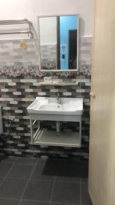 a bathroom with a white sink and a mirror at SAMMY HOOMESTAY in Ipoh