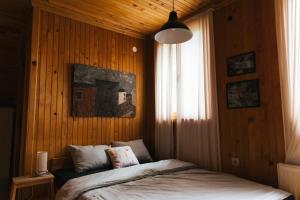 a bedroom with a bed in a wooden wall at Apartman Nana, planina Tara, Kaludjerske bare in Kaludjerske Bare