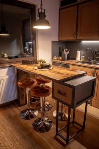 a kitchen with a wooden counter and a island with stools at BlackWood Apartment Zlatibor in Zlatibor