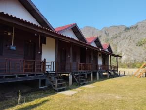a row of houses with mountains in the background at Konglor Khamchalern Guesthouse and Restaurant in Ban O