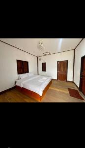 a bedroom with a large white bed in it at Konglor Khamchalern Guesthouse and Restaurant in Ban O