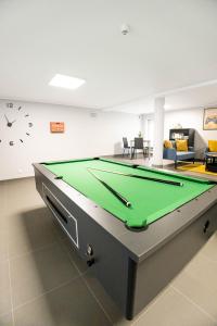 a living room with a pool table and a clock at Dom Studencki Komenik in Leszno