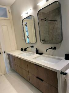 uma casa de banho com 2 lavatórios e um espelho grande em Eco Luxury apartment LISBOA-Campo de Ourique em Lisboa