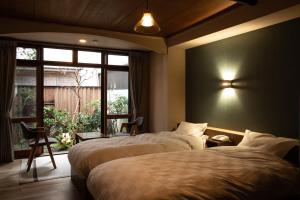 豐岡的住宿－城崎温泉 旅館 つばき乃 - Kinosaki Onsen Ryokan Tsubakino，酒店客房设有两张床和窗户。