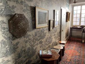 a living room with a wall with wallpaper at Le Clos Rodolphe in Beaulieu-sur-Dordogne
