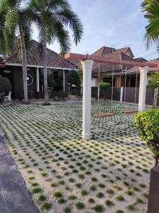 een tuin met palmbomen en een huis bij Villa Sayang Humairah @ Venice of Perak Intan 2 in Lumut