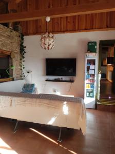 uma sala de estar com uma cama e uma televisão em Albergue La Casa del Camino em Valverde de la Virgen