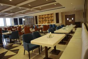 um restaurante com mesas e cadeiras num quarto em The Mars Resorts em Meerut