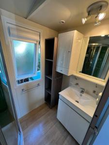 a small bathroom with a sink and a window at Bungalow luxe 3 chambres surplombant le Golf de St Tropez in Gassin