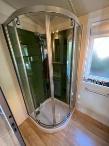 a glass shower in a room with a window at Bungalow luxe 3 chambres surplombant le Golf de St Tropez in Gassin