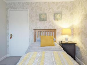 a bedroom with a bed with a yellow pillow on it at Cissa in Chichester
