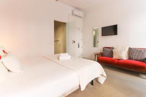a bedroom with a white bed and a red couch at Chiado Prime Suites by Homing in Lisbon