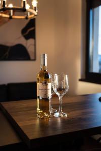 a bottle of wine and a glass on a table at BlackWood Apartment Zlatibor in Zlatibor
