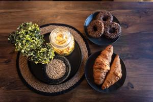 a wooden table with plates of food and pastries at BlackWood Apartment Zlatibor in Zlatibor