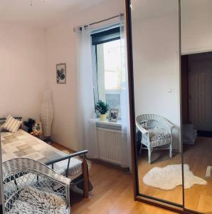 un miroir dans une chambre avec une chaise et une fenêtre dans l'établissement Apartament Blisko Morza Świnoujście, à Świnoujście